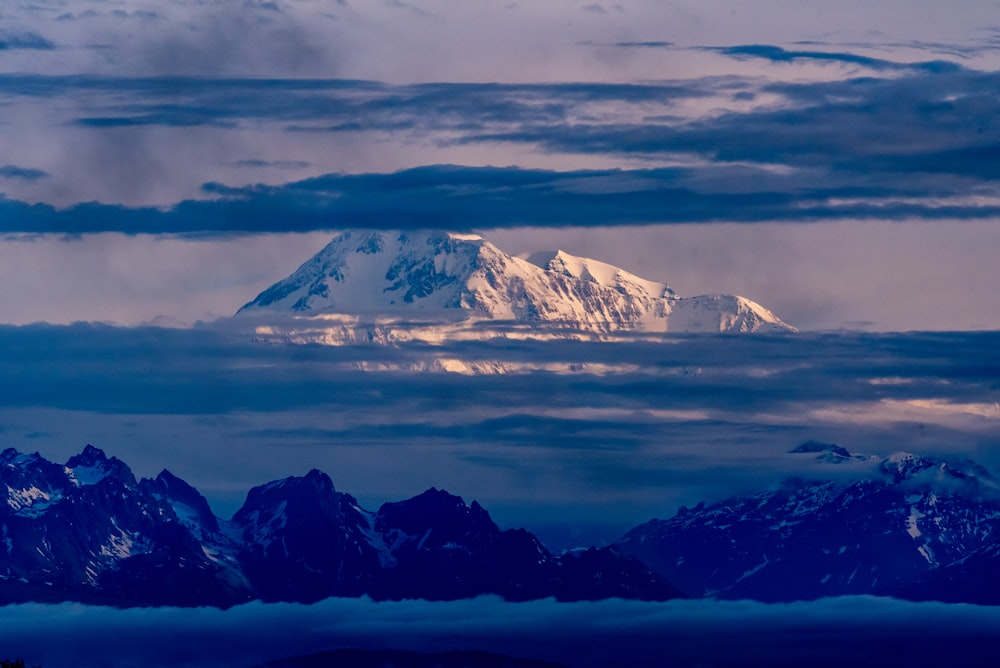 snow covered mountain under cloudy sky during daytime