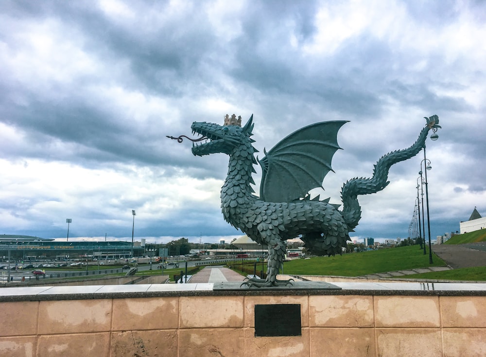 statua del drago nero sotto il cielo nuvoloso durante il giorno