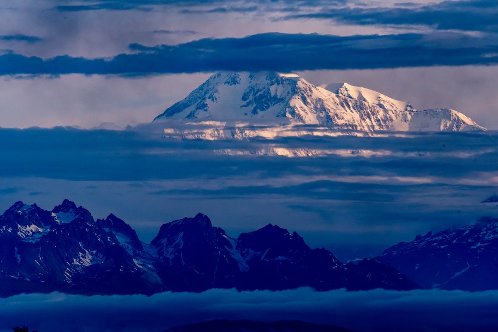 snow covered mountain under cloudy sky during daytime