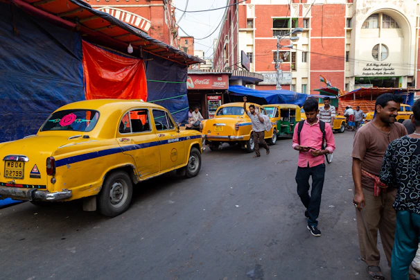 A group of smiling tourists stepping out of a Darpan taxi in a busy market area.