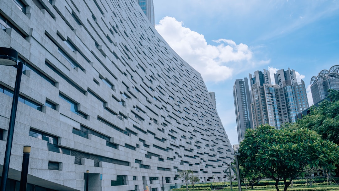 white concrete building under white clouds during daytime