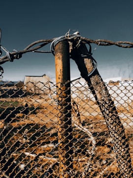 Operator installing a chain link fence post with the tractor’s attachments.