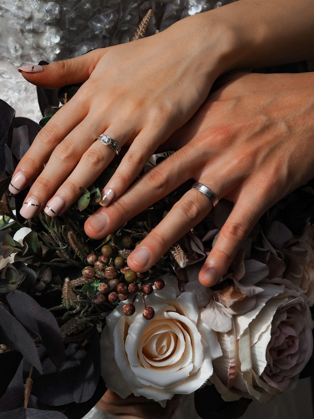 person wearing silver ring and gold ring