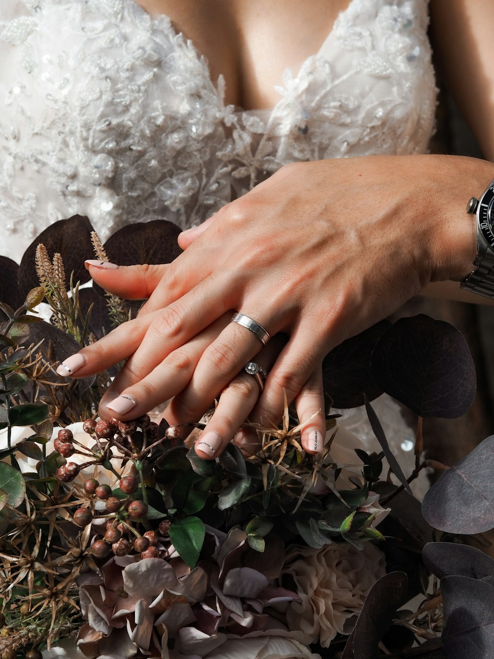 person wearing silver ring holding green plant