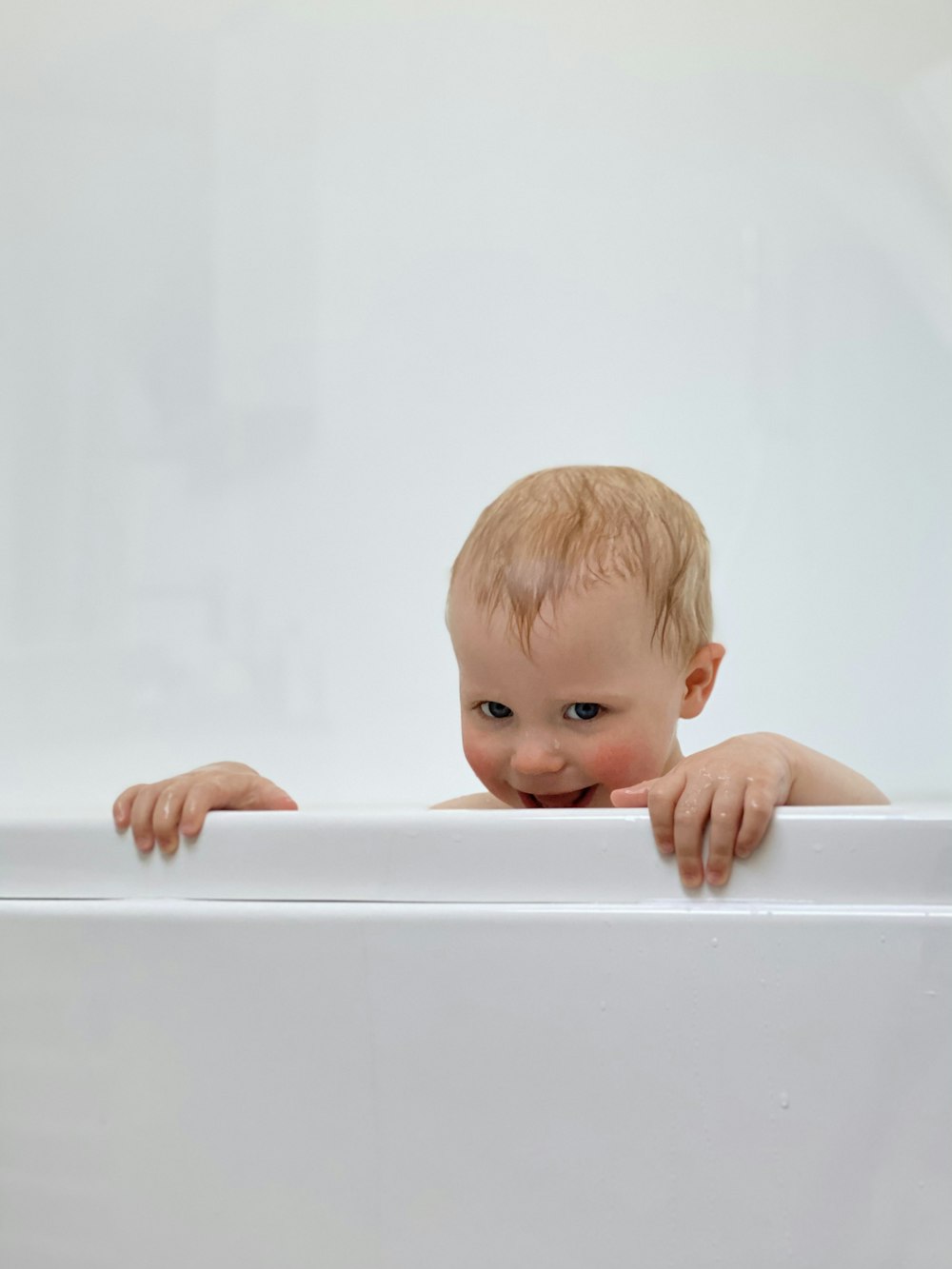 baby in white bathtub with water