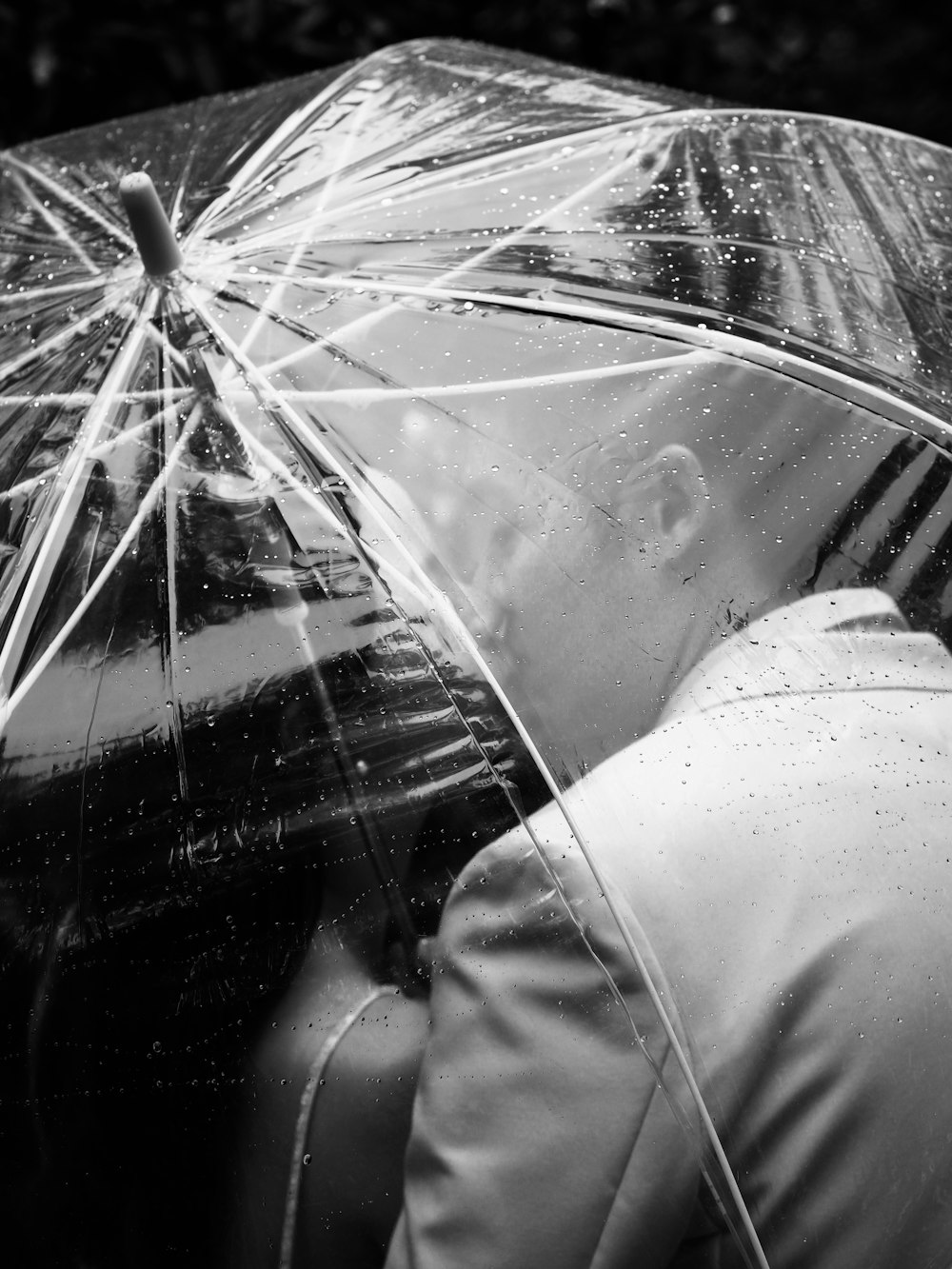 person in white pants holding clear umbrella