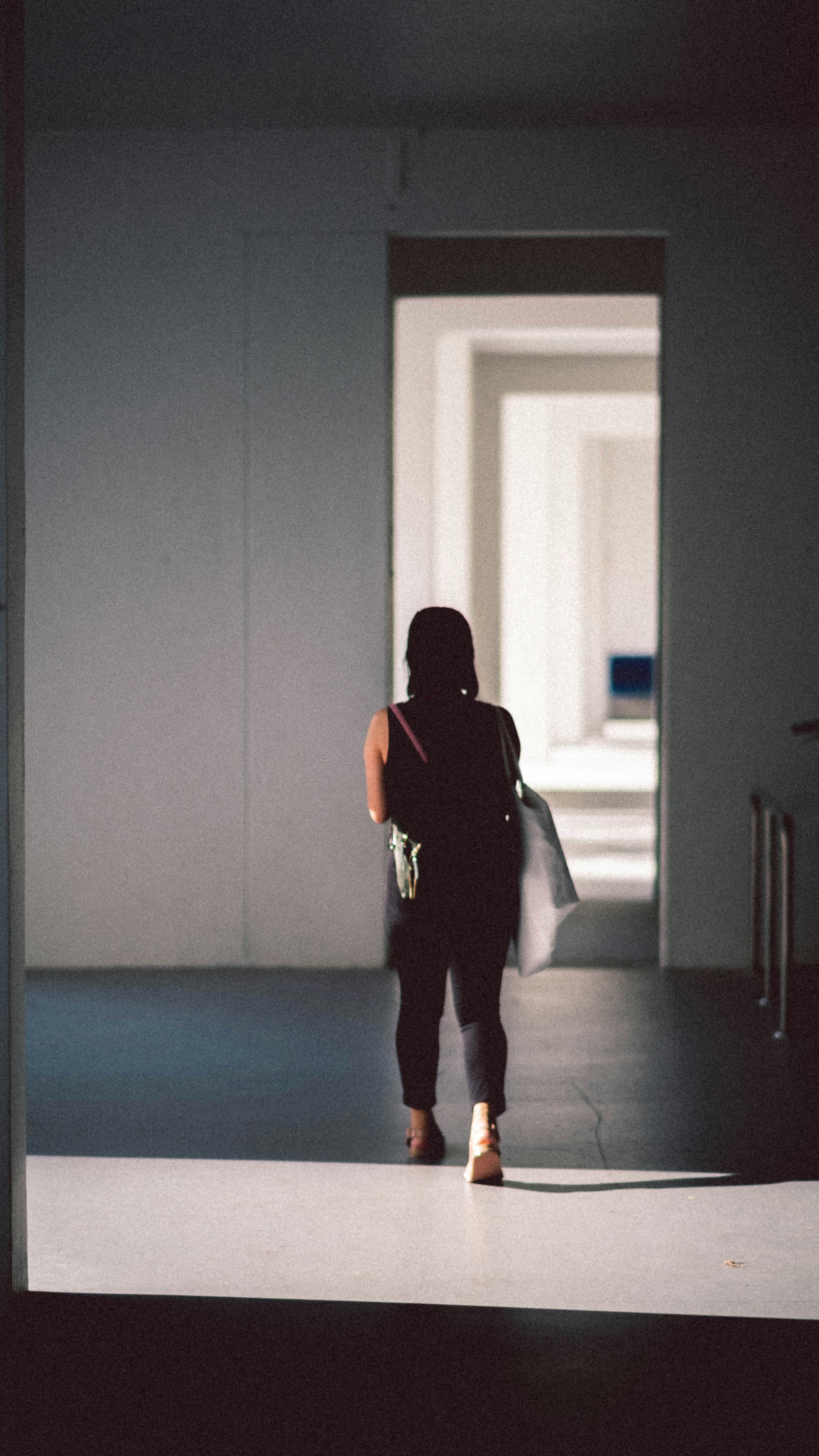man in black t-shirt and white pants standing in hallway