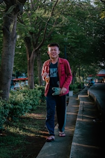 A customer happily wearing rubber shoes while walking on a leafy path.