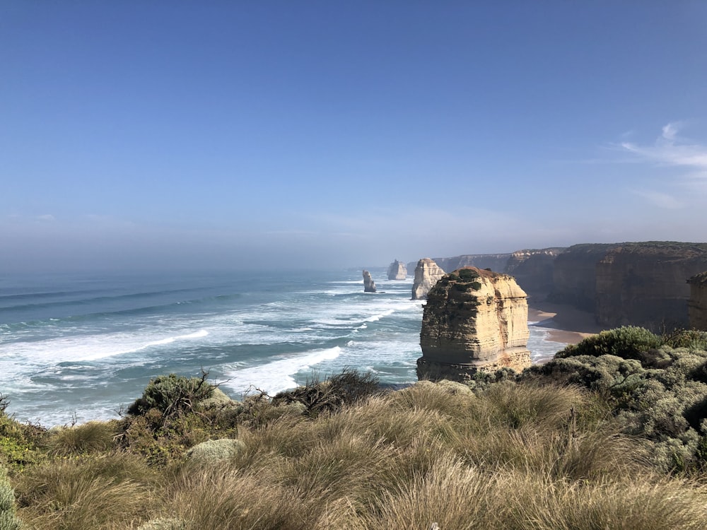 brown rock formation near body of water during daytime