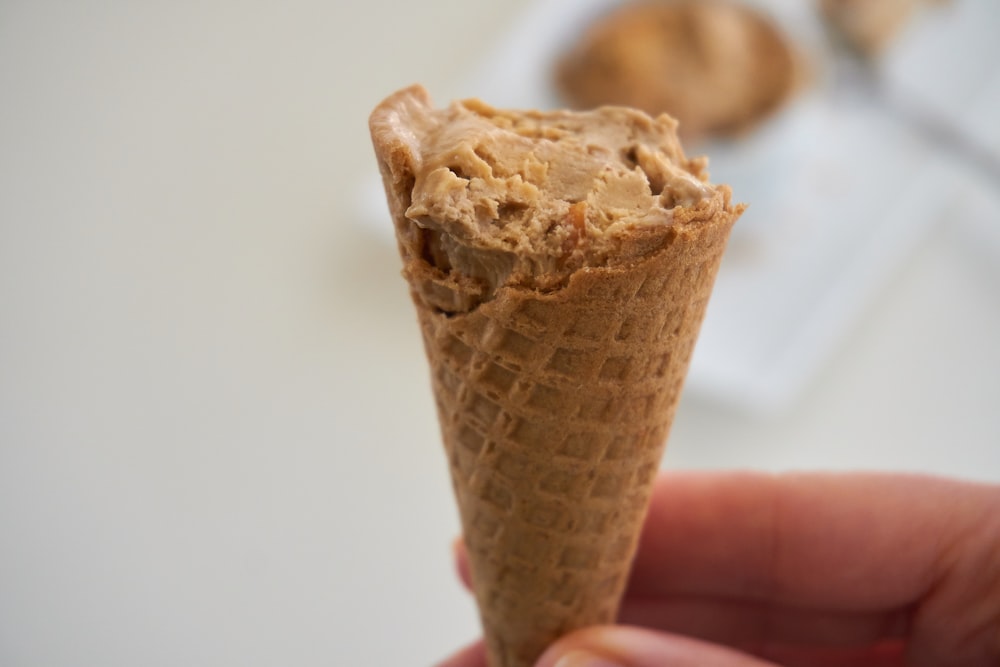 person holding brown ice cream cone