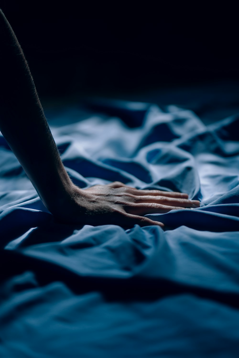 persons hand on blue textile