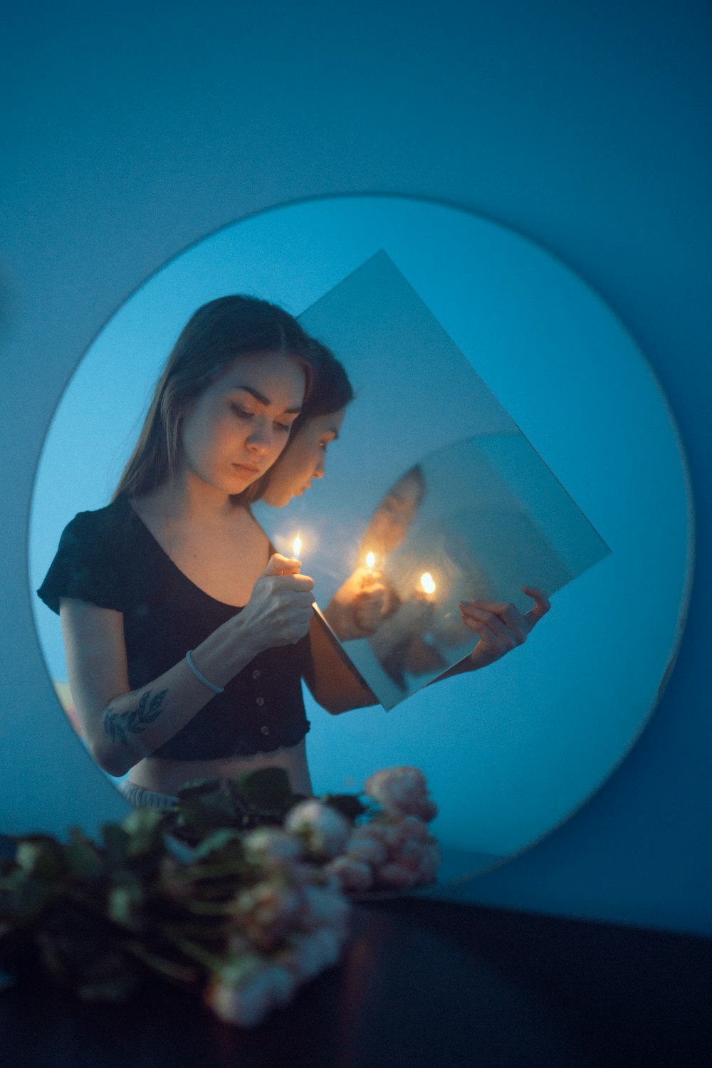 woman in black tank top holding lighted candle