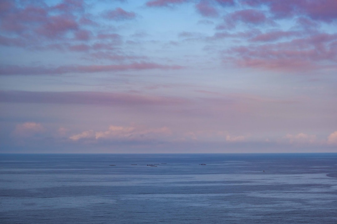 body of water under cloudy sky during daytime