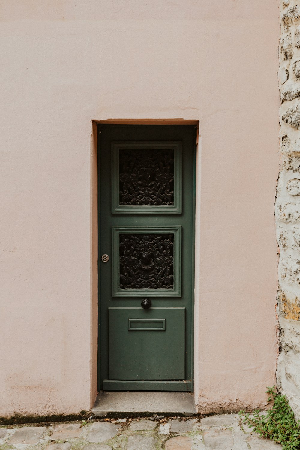 puerta de madera negra sobre pared de hormigón blanco