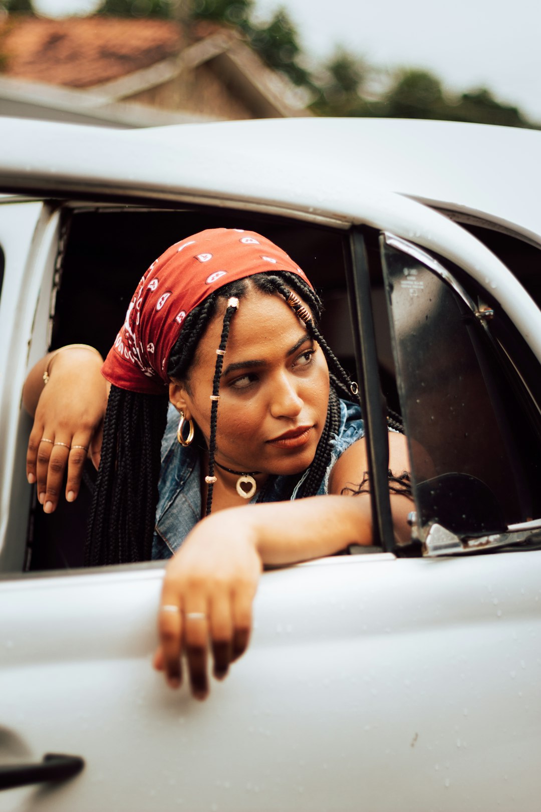 woman in black sleeveless top wearing red and white hijab inside car