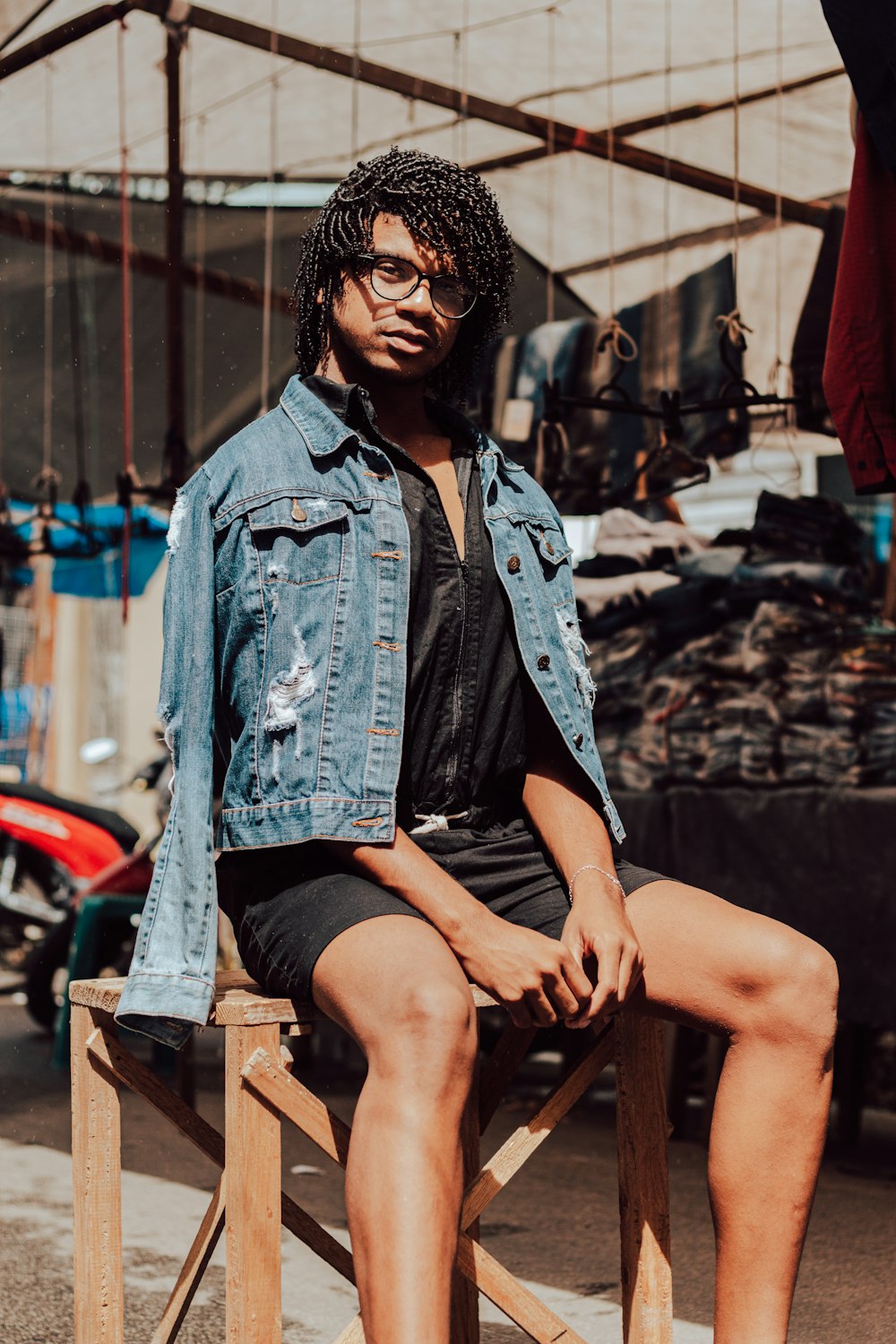 woman in blue denim jacket sitting on brown wooden chair