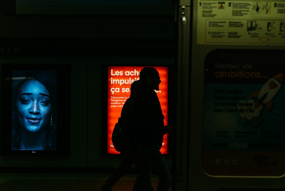 man in red jacket standing near window