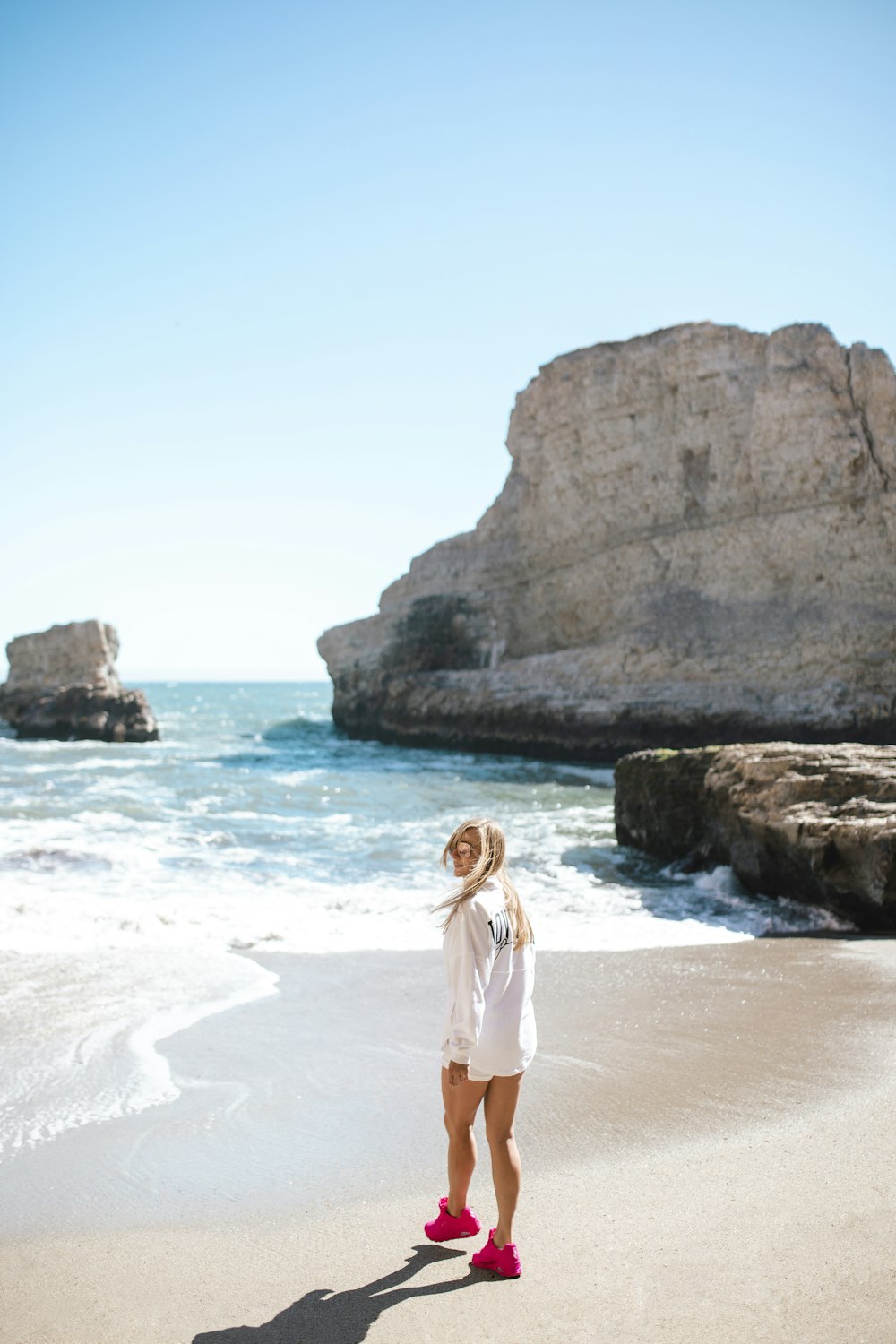 woman in white dress standing on white sand beach during daytime