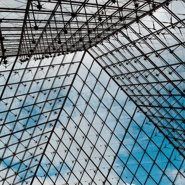 Black metal framework of a glass roof at the Louvre Museum in Paris