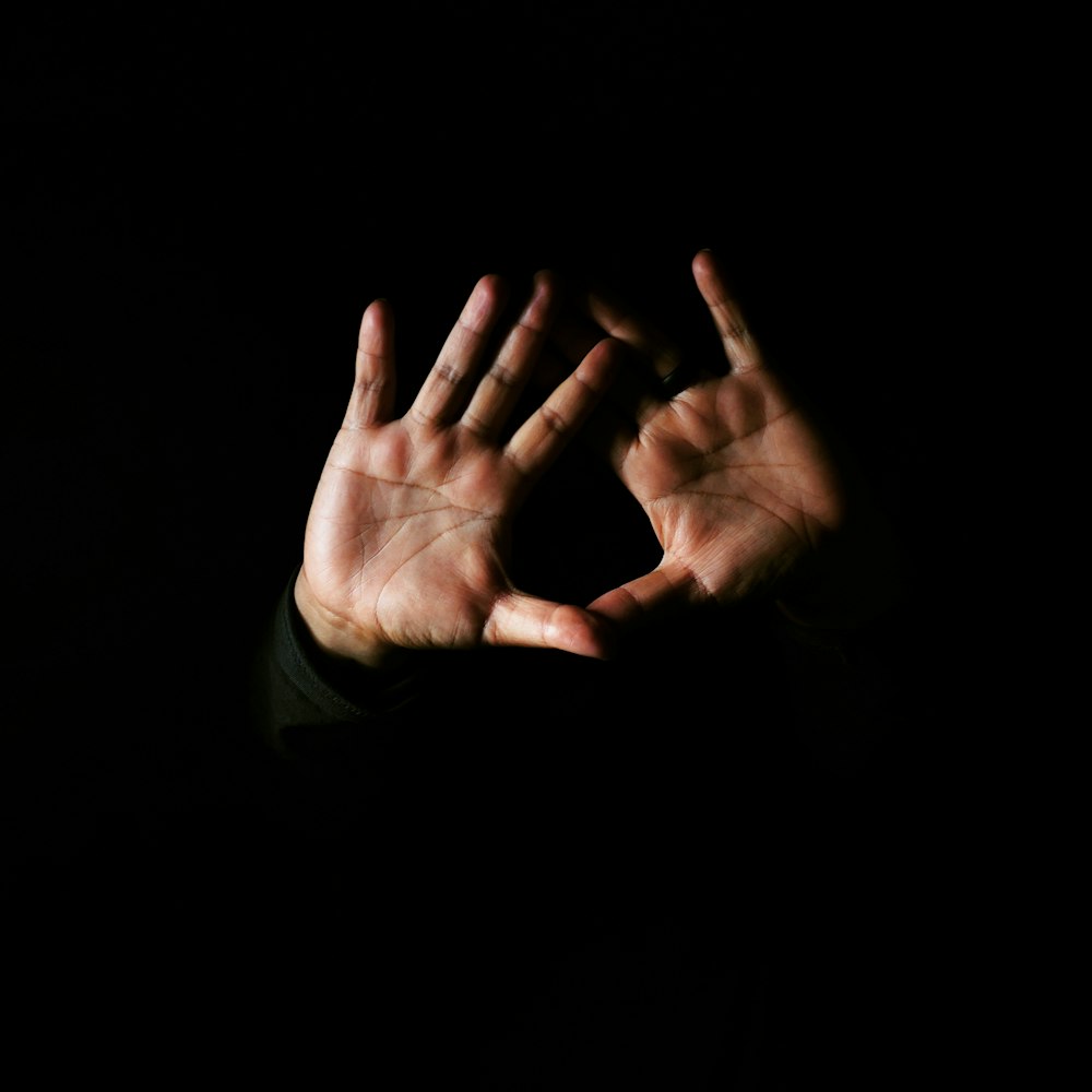 person in green long sleeve shirt showing left hand