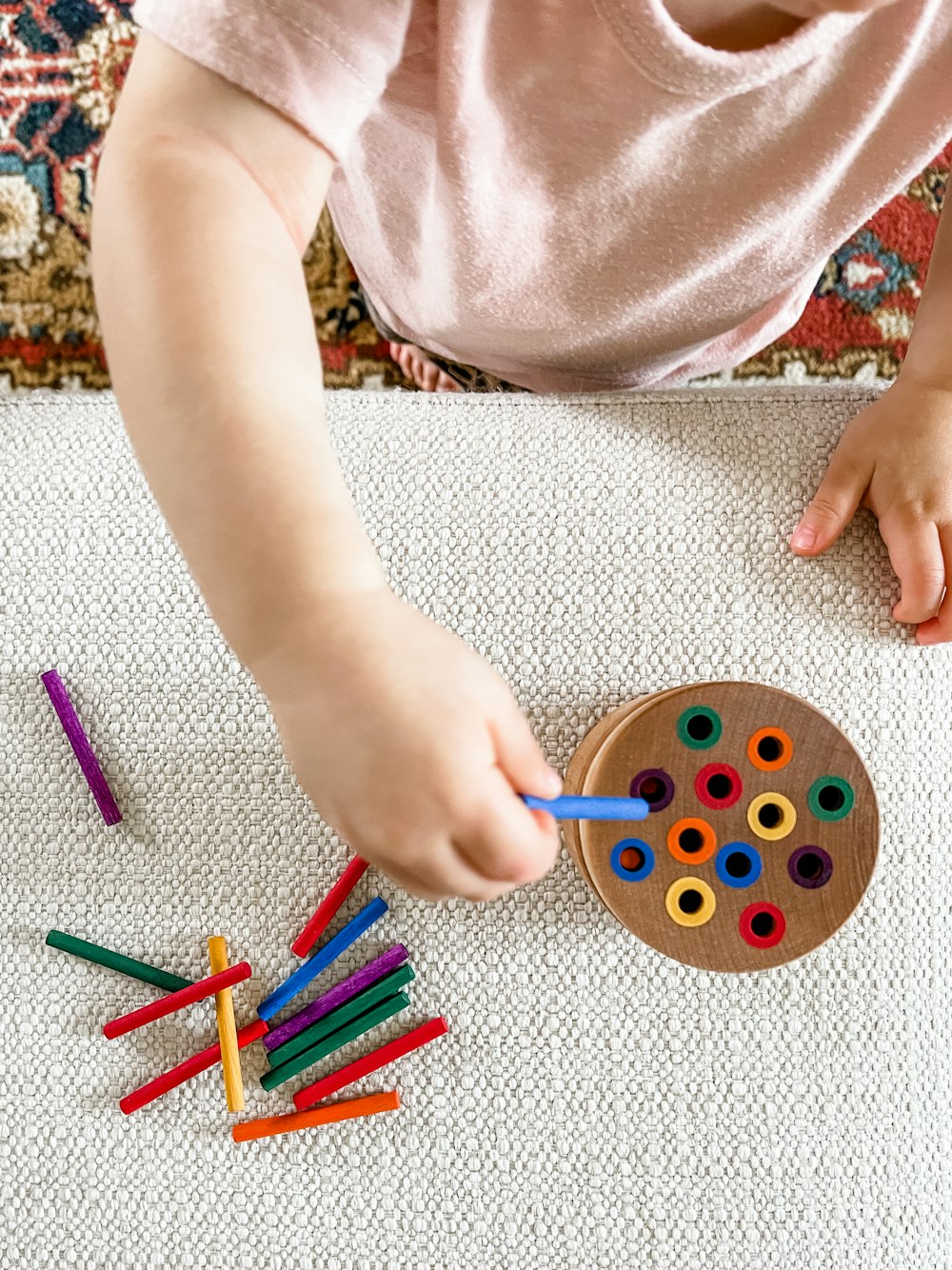 person holding blue and green round plastic toy