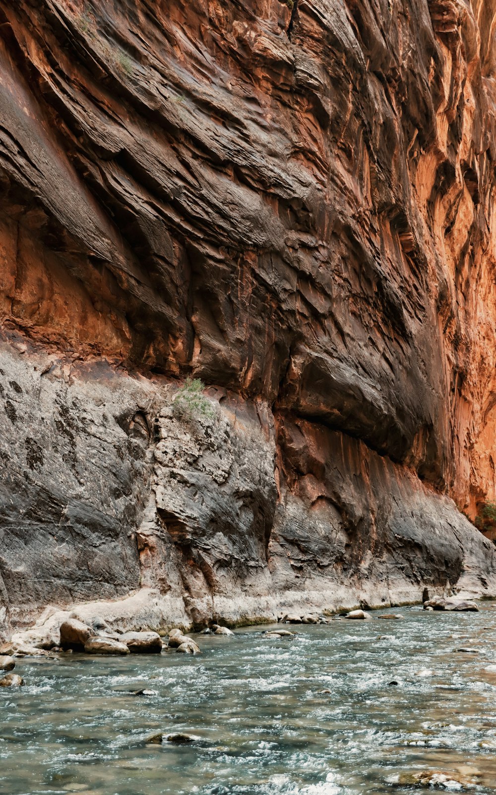 brown rock formation near body of water during daytime