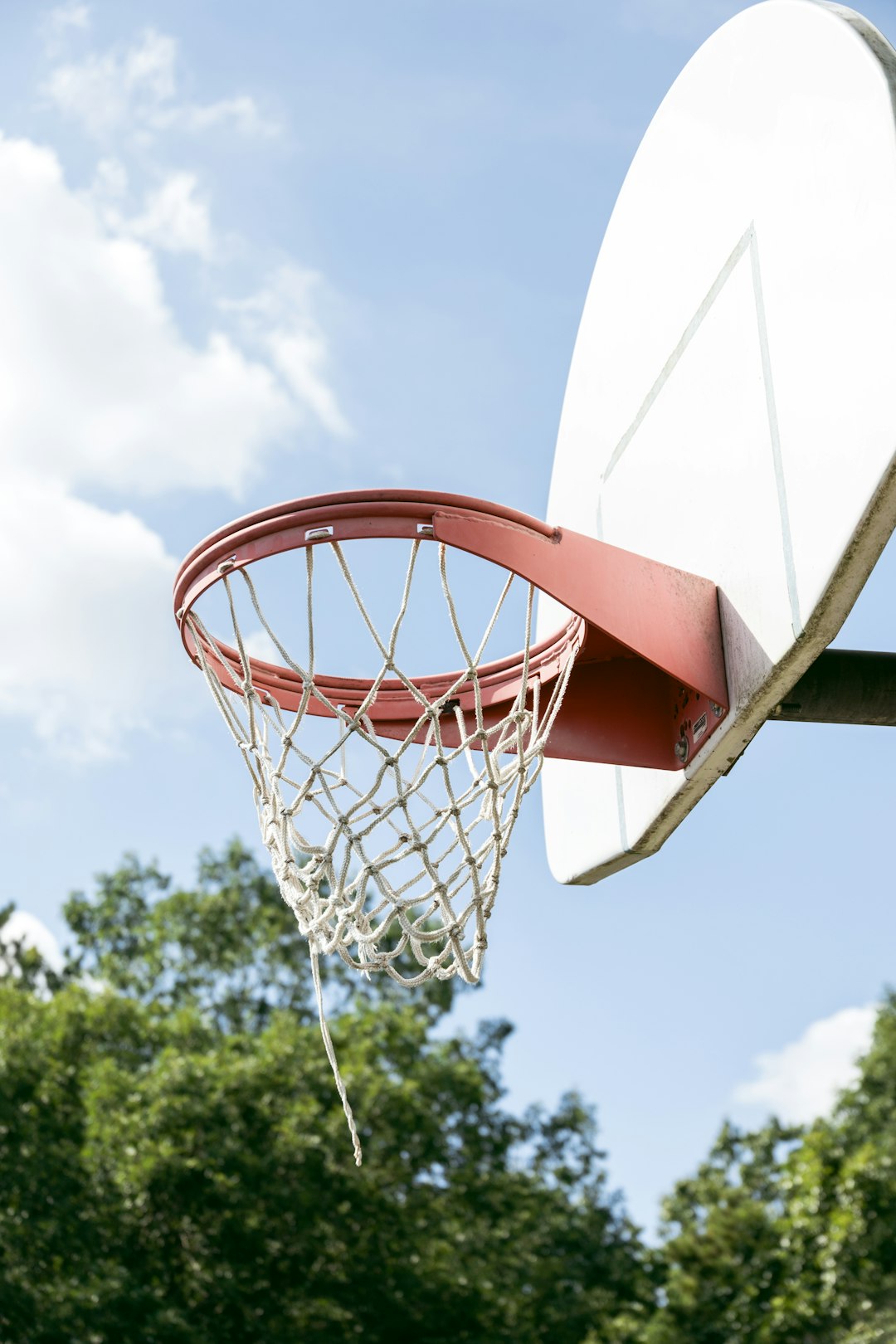 white and orange basketball hoop under blue sky during daytime