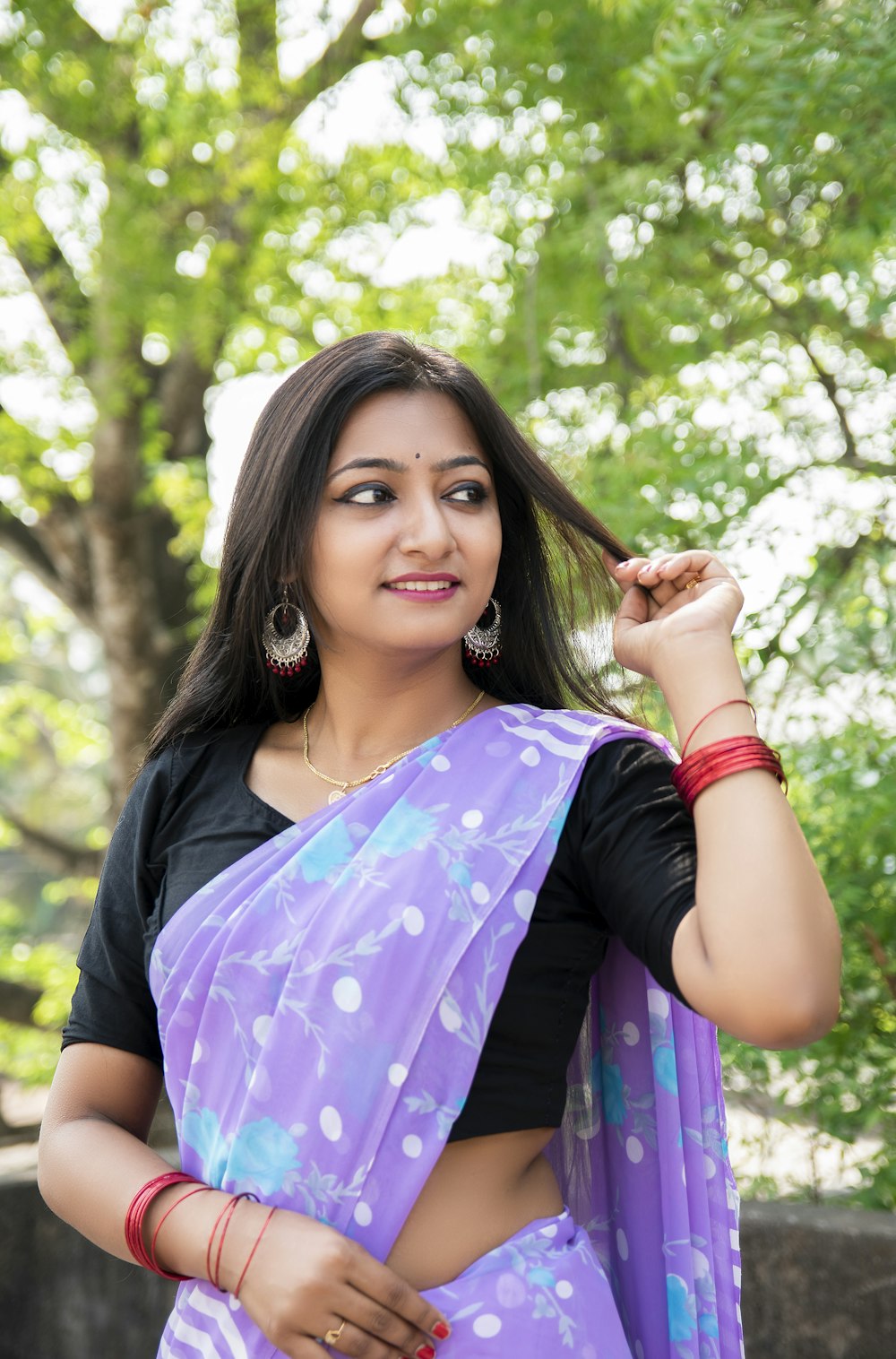 woman in purple and black floral dress smiling