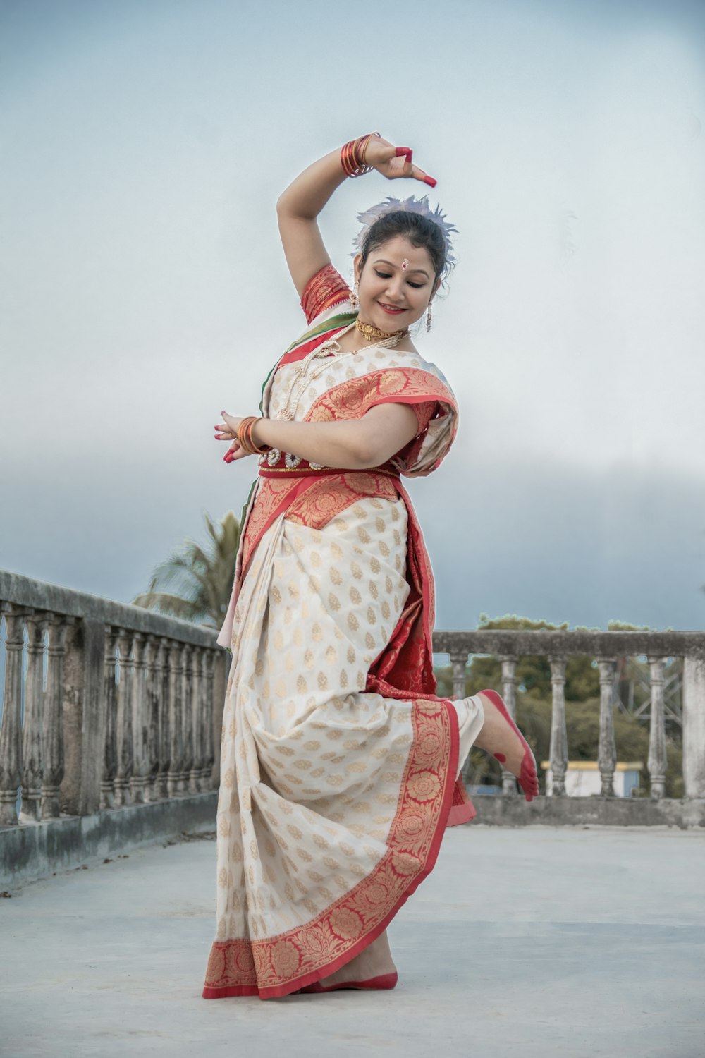 fille en robe blanche et rouge debout sur le sol en béton gris pendant la journée