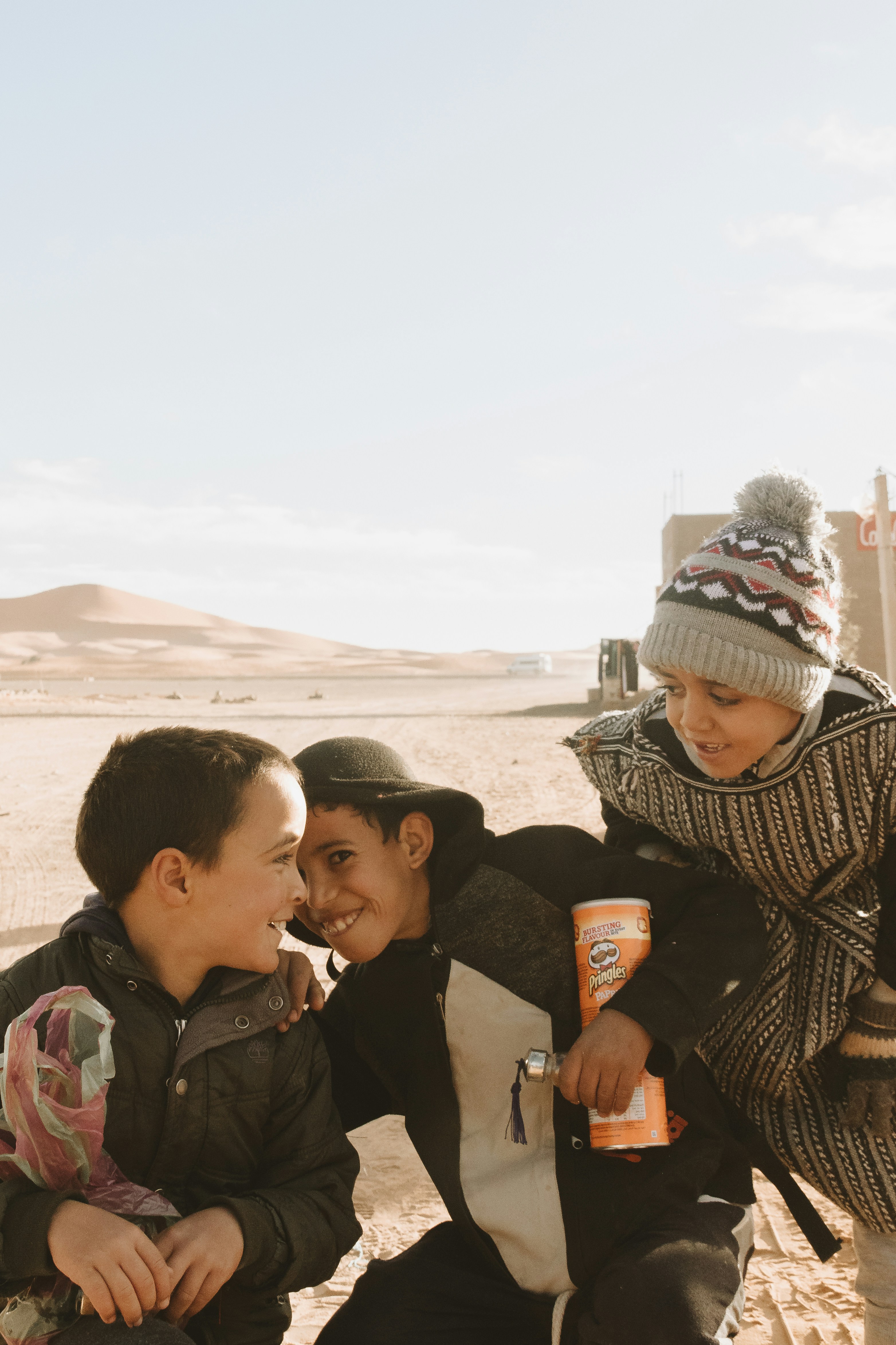 man in black and white knit cap carrying baby in black jacket