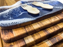 Wooden cutting boards stacked neatly, each engraved with personalized designs.