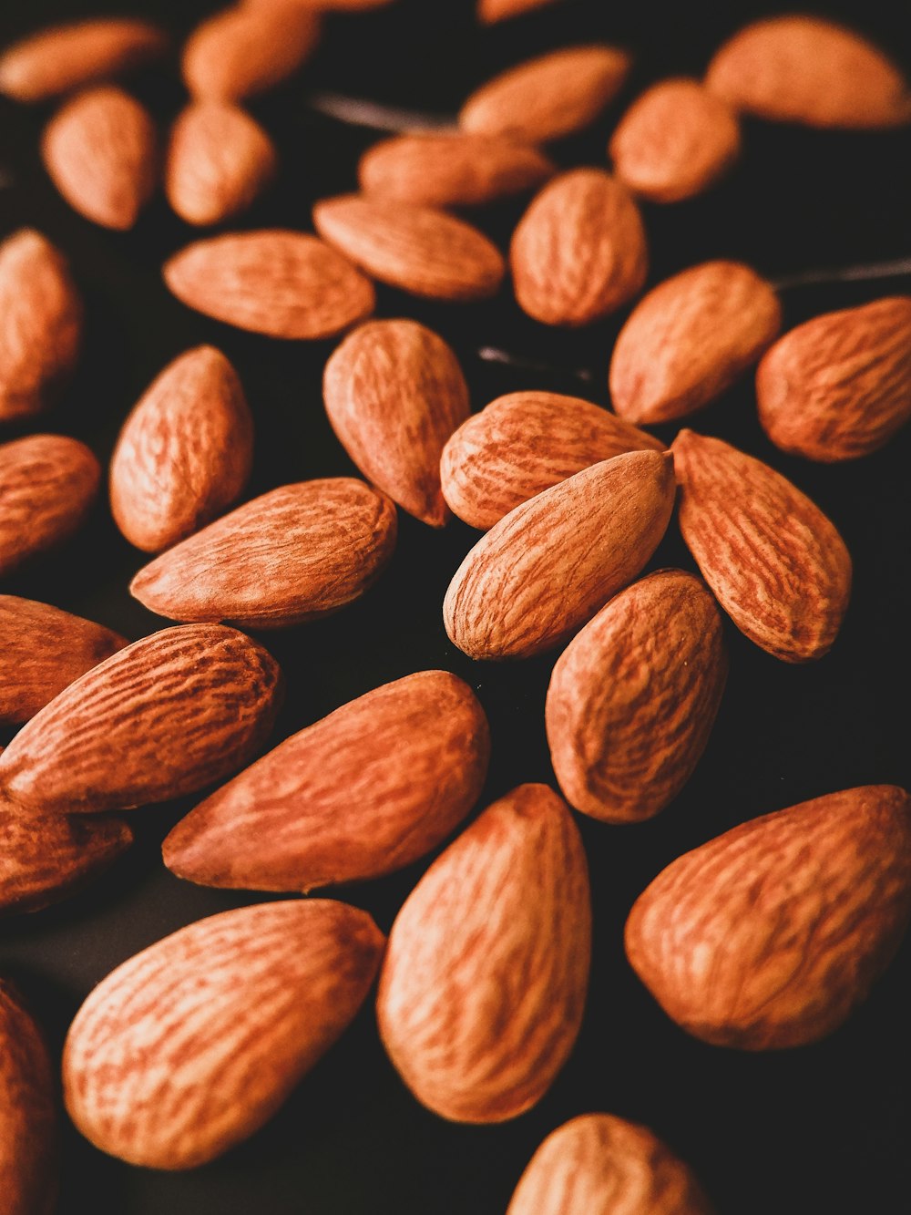 brown almond nuts on black background