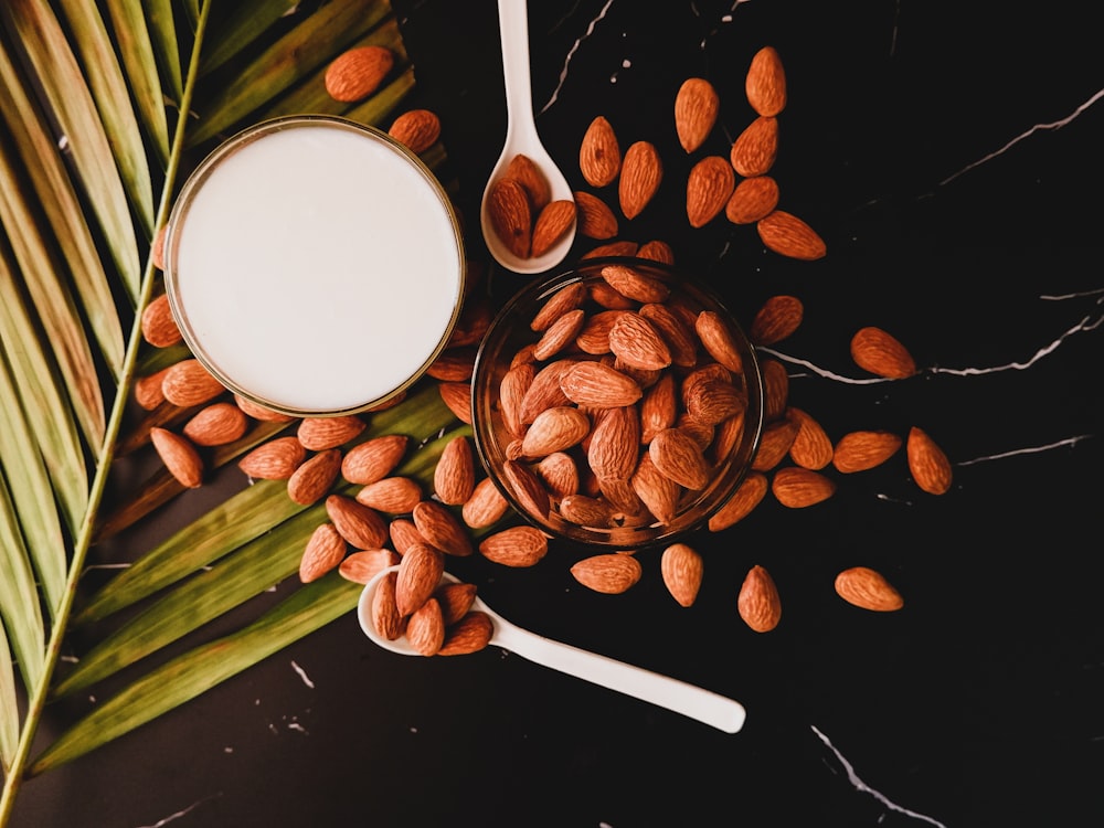 grains de café bruns sur une tasse en céramique blanche à côté d’une cuillère en acier inoxydable