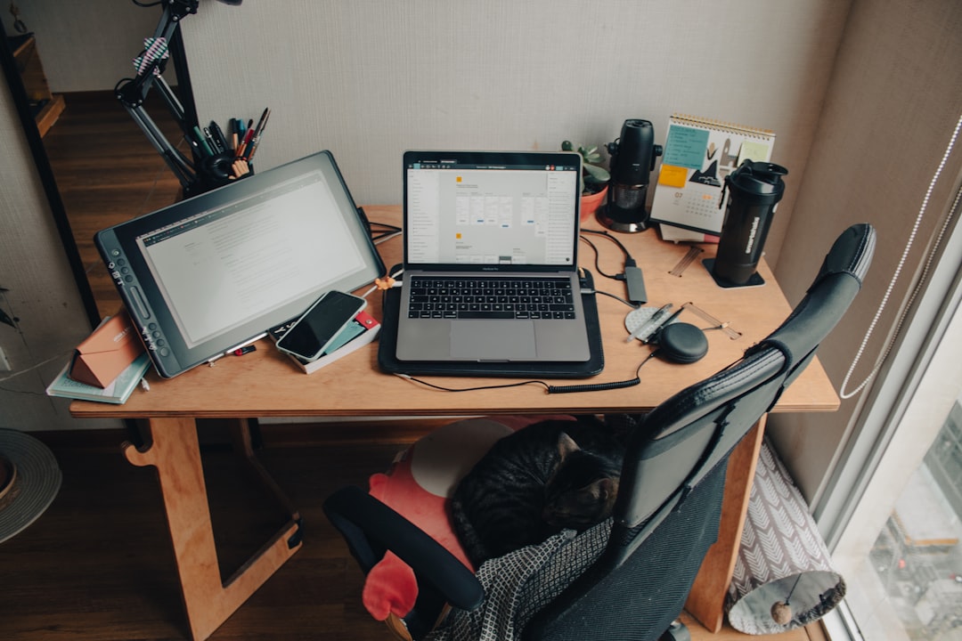 black and silver laptop computer on brown wooden desk