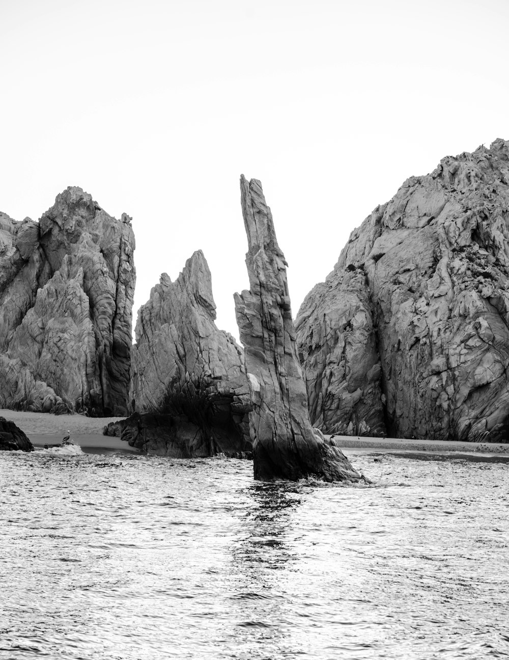 Graustufenfoto der Felsformation auf See