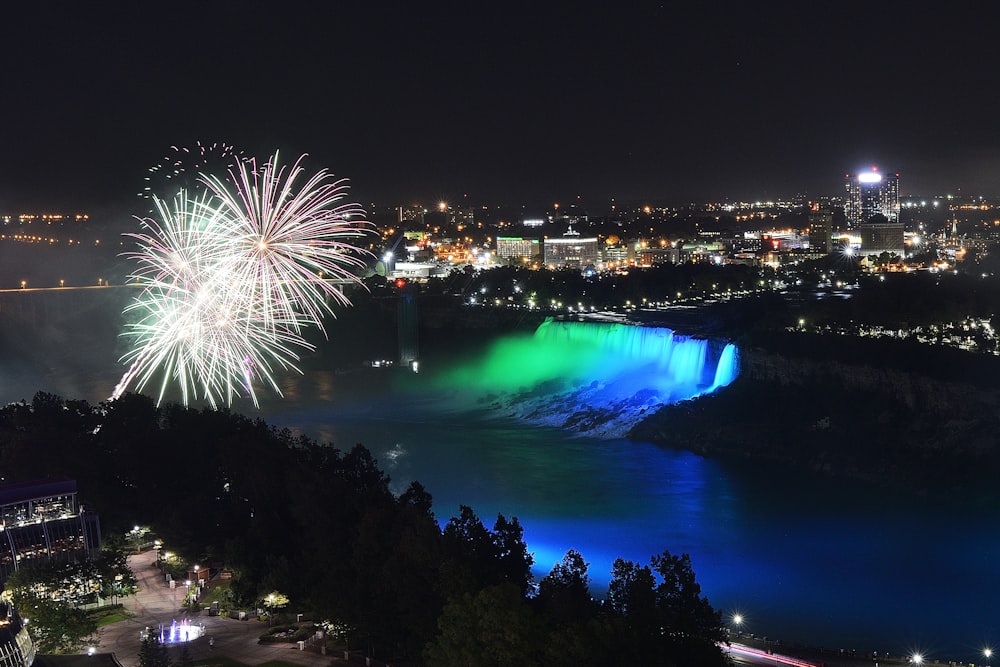 fireworks are lit up in the night sky over a city