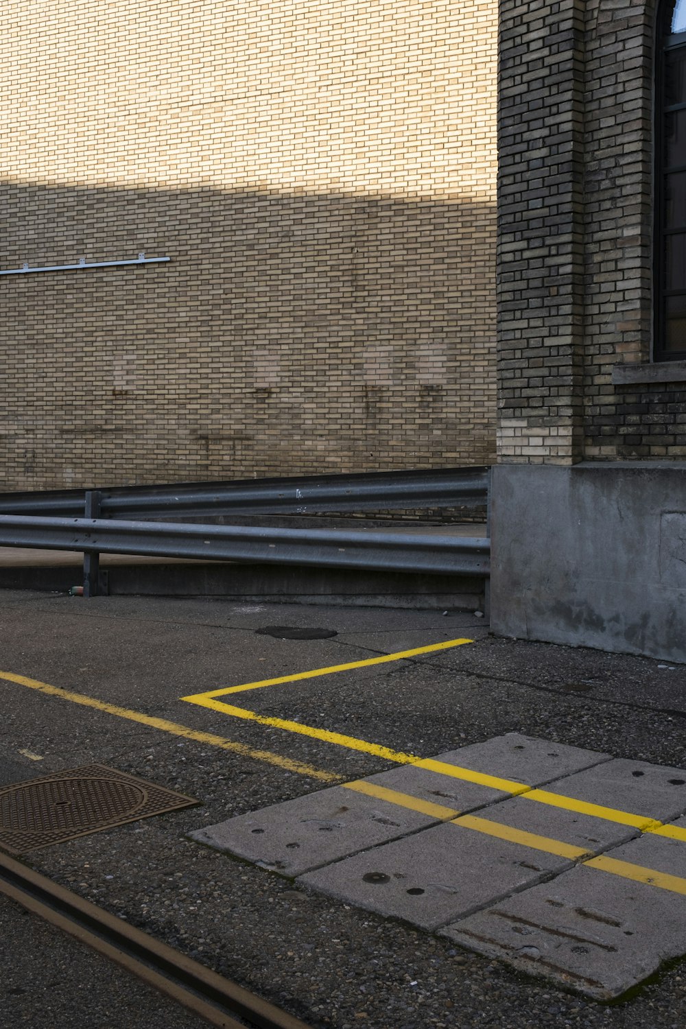 black metal fence beside brown brick wall