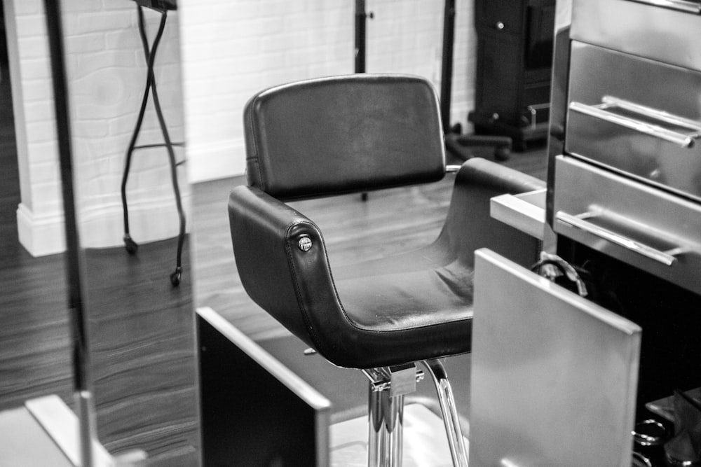 black leather padded chair in grayscale photography