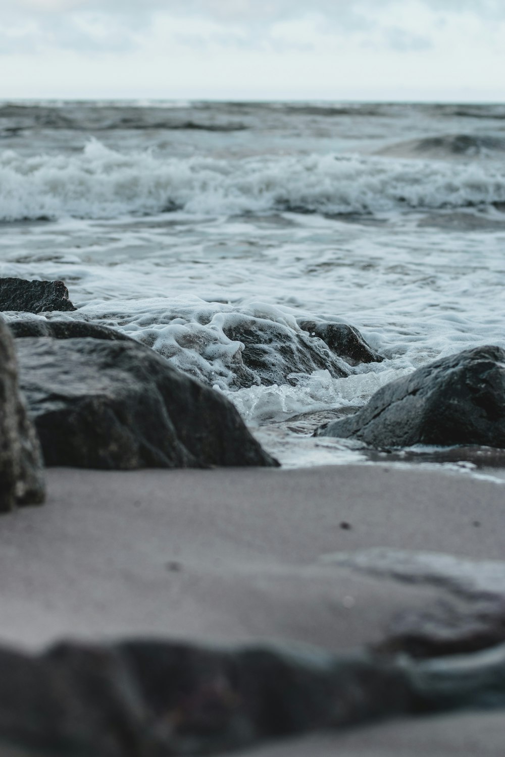 costa rocosa gris con olas de agua durante el día