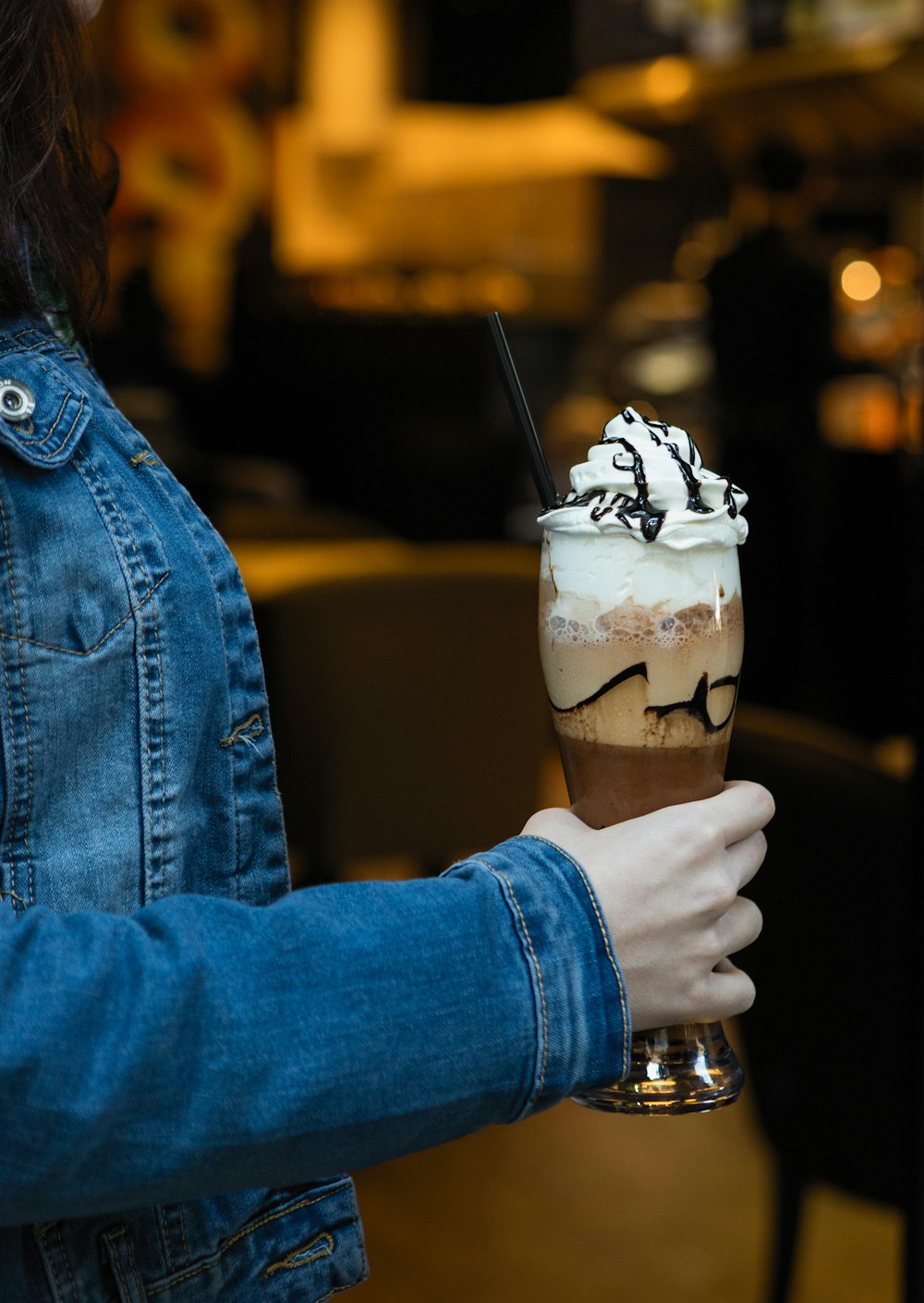 person in blue denim jacket holding ice cream cone with ice cream