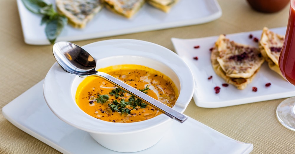 sopa em tigela de cerâmica branca com colher