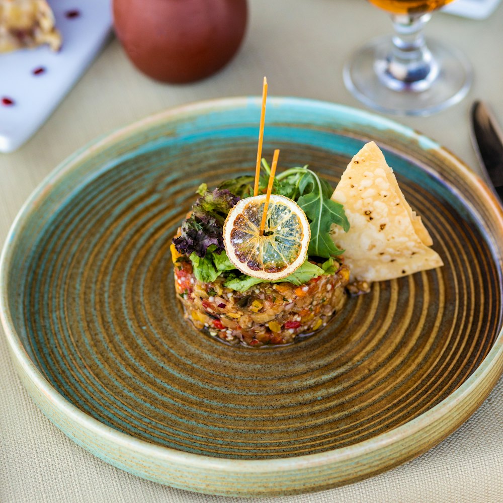 brown and green dish on blue ceramic round plate