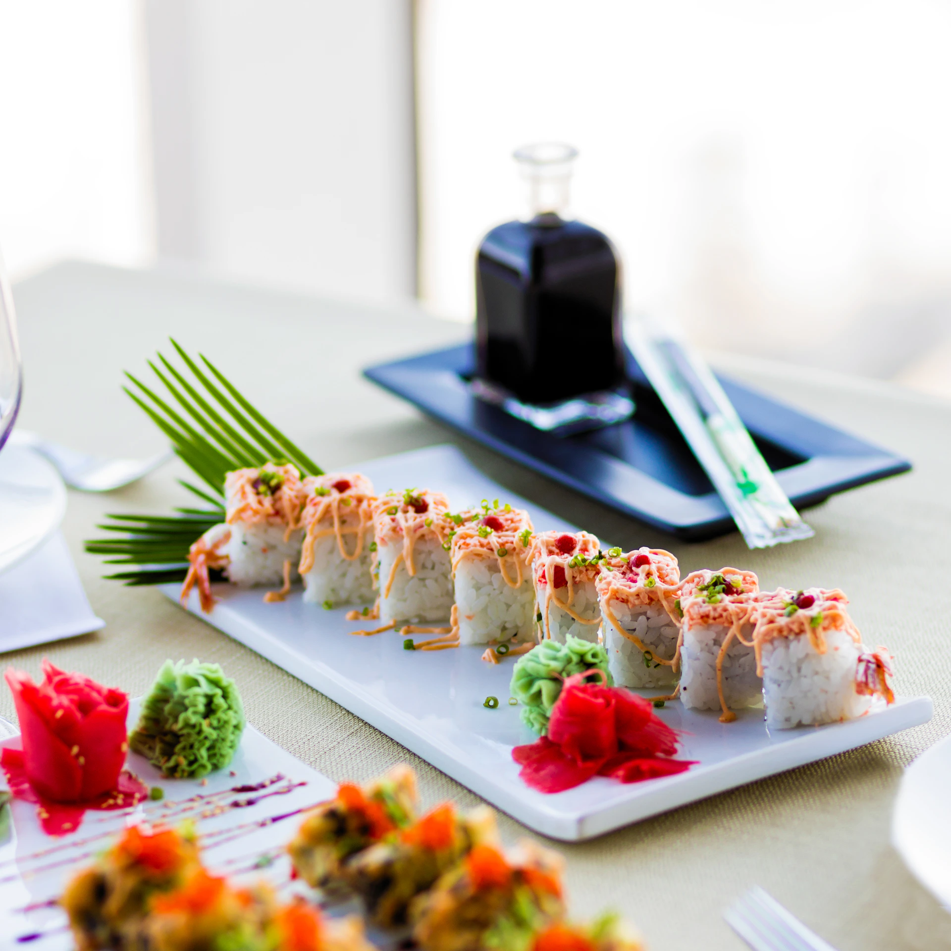 An inviting table setting featuring a variety of sushi rolls, soy sauce dishes, and chopsticks ready for a delicious meal.
