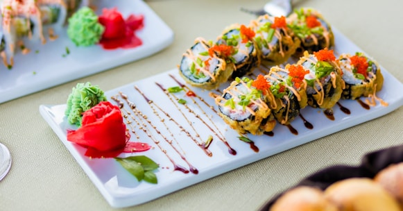 Elegant presentation of a colorful sushi roll topped with fresh ginger slices.