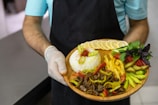 person holding brown round plate with burger