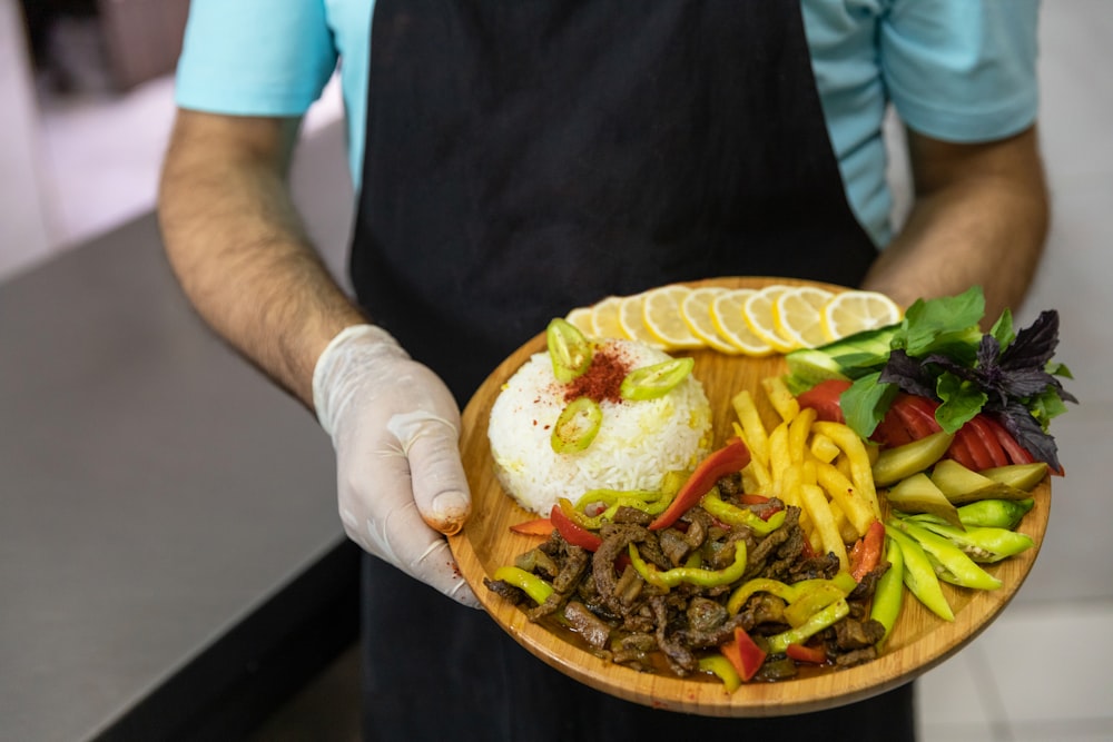 Person mit braunem rundem Teller mit Burger