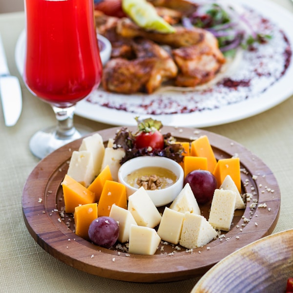 Sliced cheese on brown wooden plate