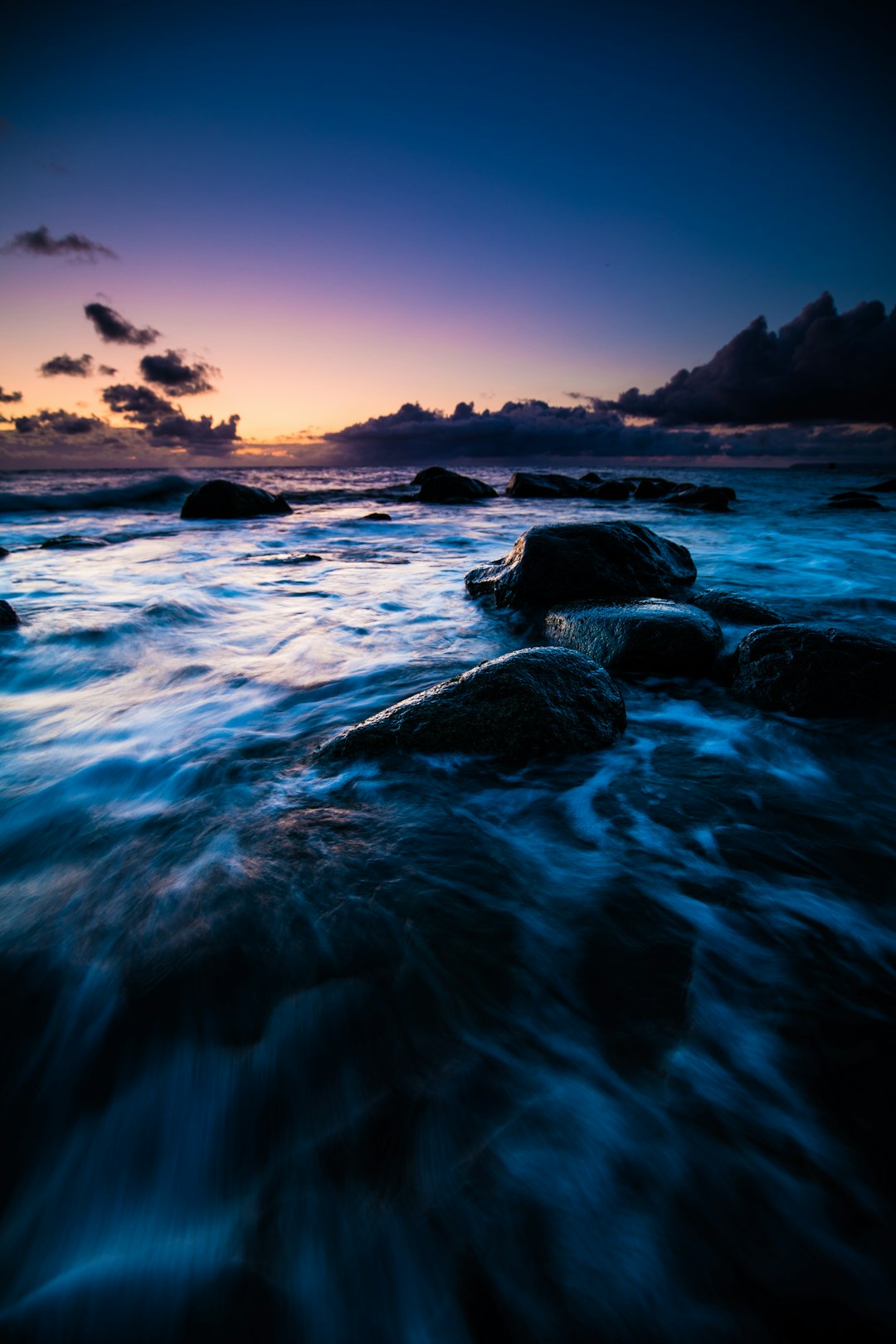 ocean waves crashing on rocks during sunset