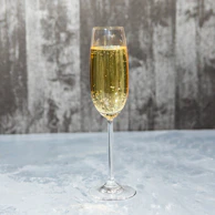 Close-up of a sparkling champagne flute with golden bubbles rising elegantly.