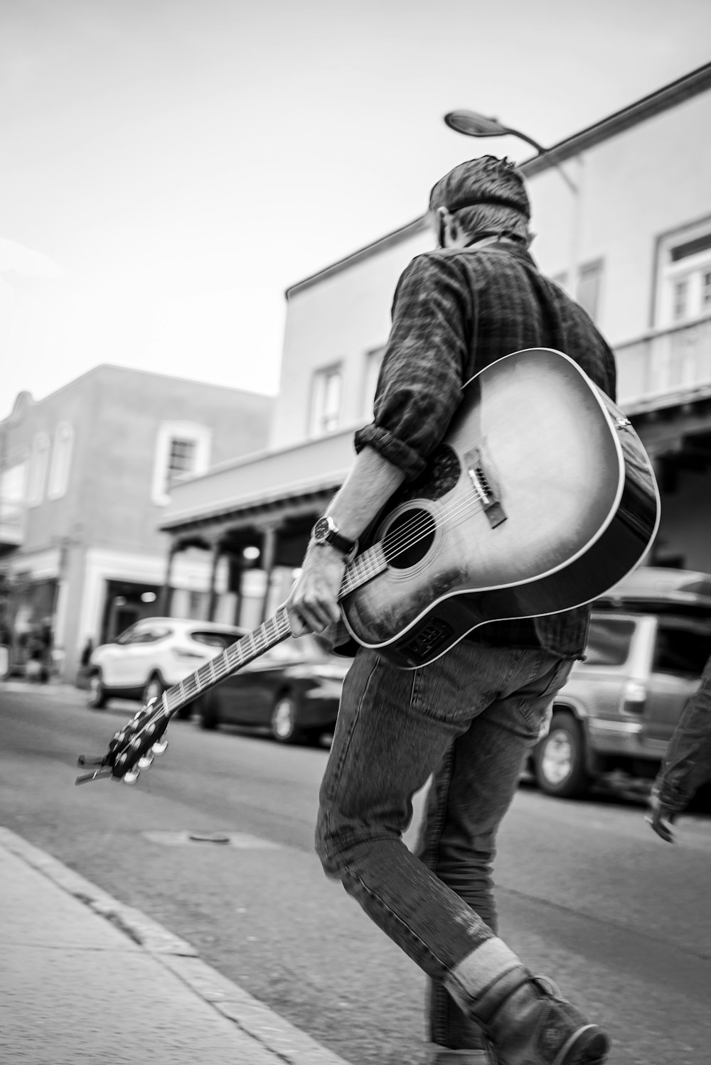 man playing acoustic guitar in grayscale photography